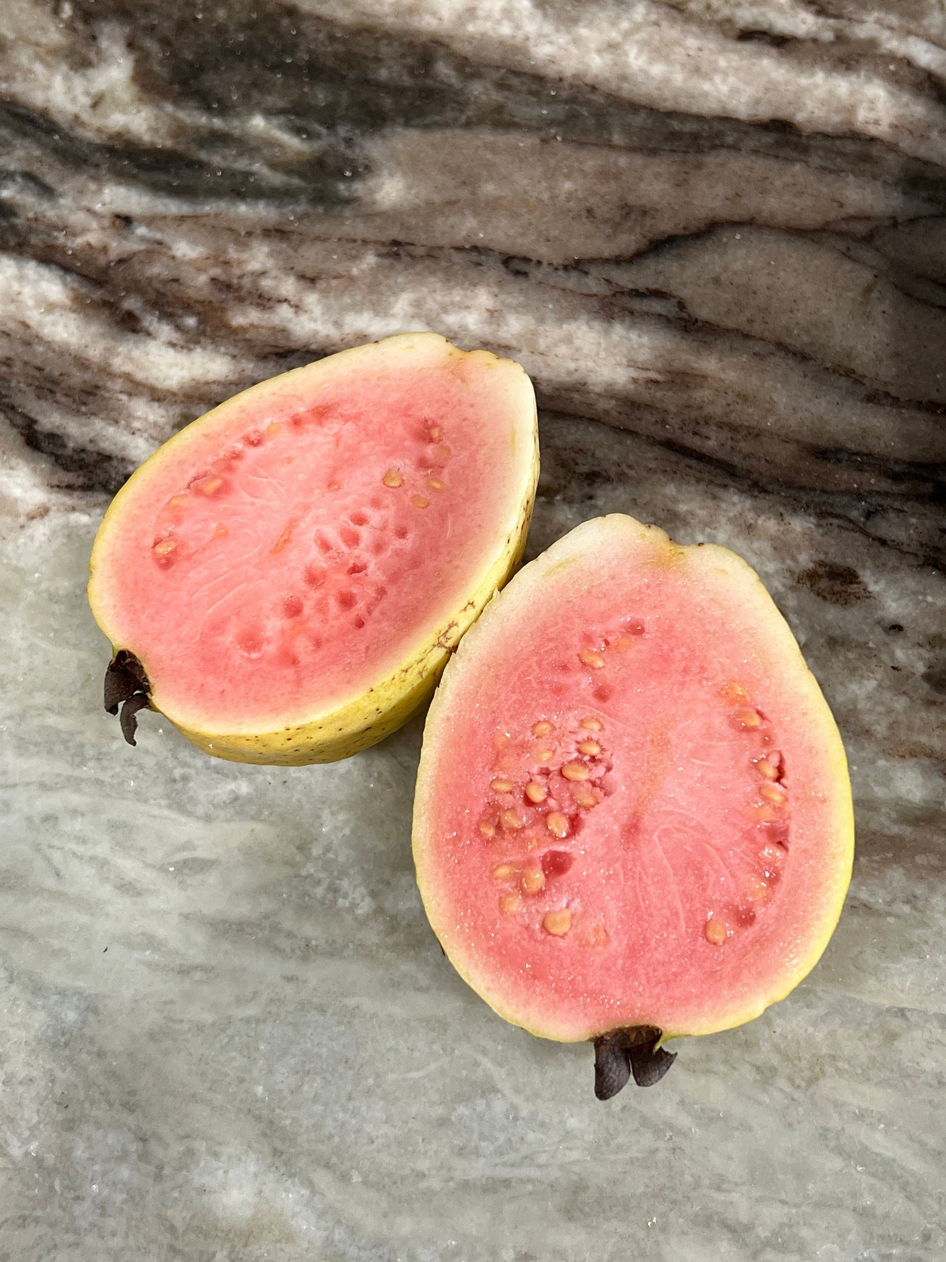 "Close-up of ripe Tikal Guava fruit, showcasing its vibrant color and inviting aroma, perfect for enjoying fresh or using in culinary creations."